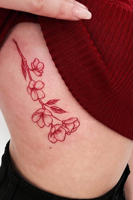 Red Ink Flower Rib Tattoo